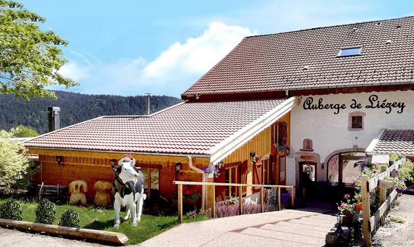 Ferme typique vosgienne avec montagnes en fond