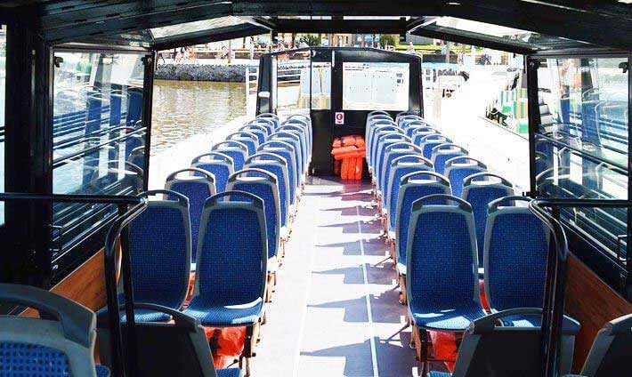 Intérieur avec sièges bleus, une partie dehors et une partie couvert