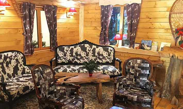 Décor tout en bois avec canapé cuir vache et table basse en bois massif