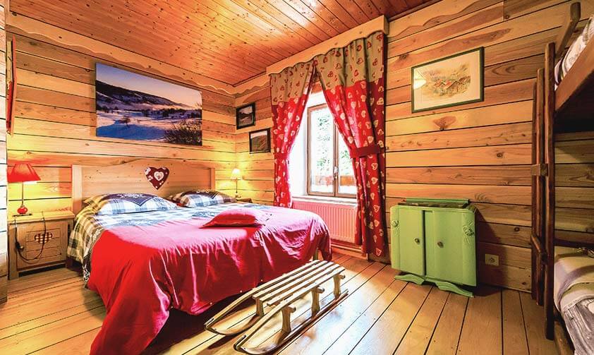 Chambre avec un lit double et un lit superposé, ambiance chalet tout en bois