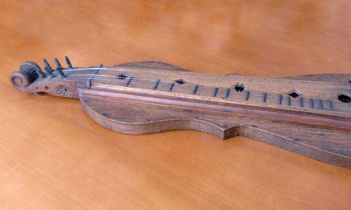 Petit instrument en bois ressemblant à une guitare et à un violon