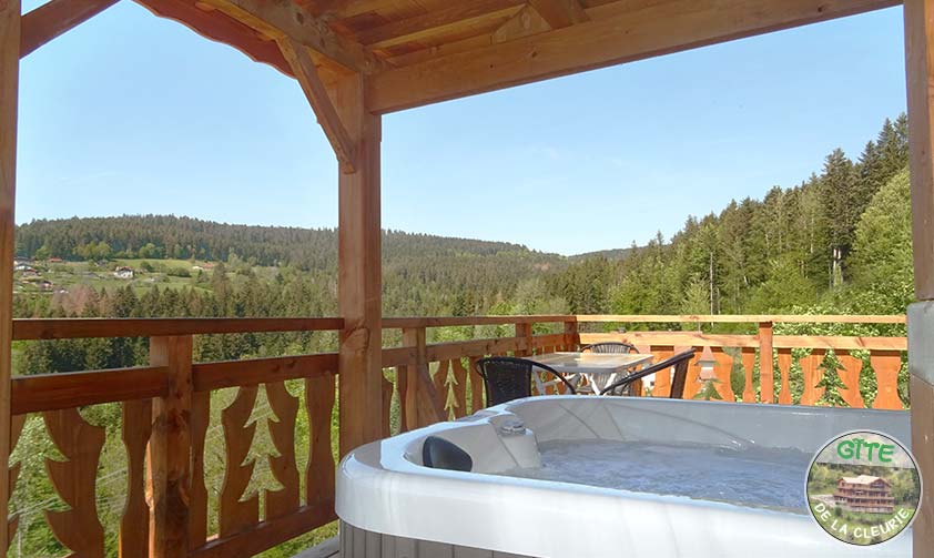 <p>SPA privé couvert avec une table sur le grand balcon, vue sur les sapins des Vosges</p>