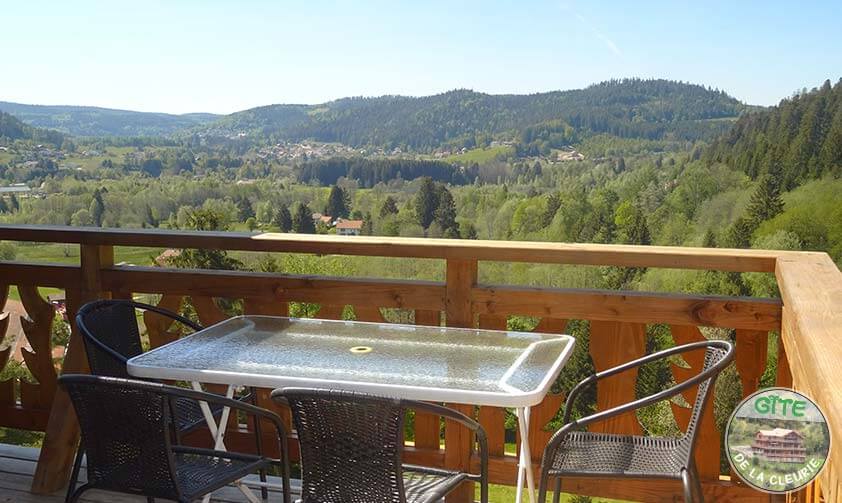 <p>Grand balcon en bois massif avec table et vue magnifique sur les montagnes des Vosges</p>