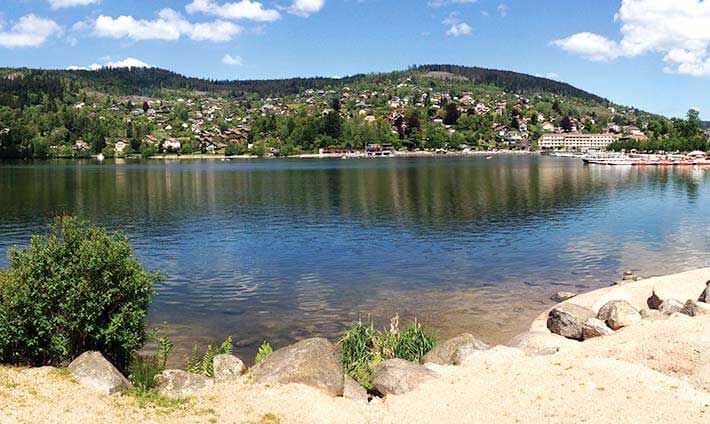 Le lac de Gérardmer vue du bord de l’eau avec les montagnes en arrière plan