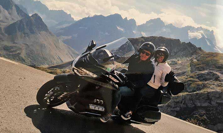 Serge et Sandrine sur leur moto avec vue sur les Alpes