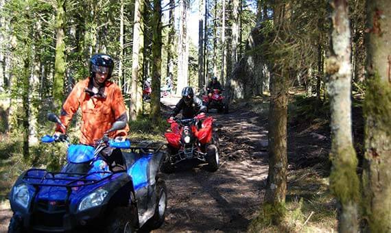Sur un chemin de forêt, on suit le moniteur en quad