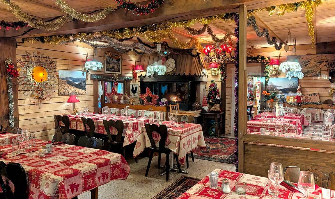 Salle de restaurant décoré avec des guirlande au coin du feu