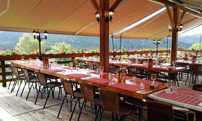 Grand table pour les groupes sous grand parasol et vue sur la vallée