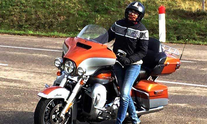 Sandrine debout à côté de sa moto orange