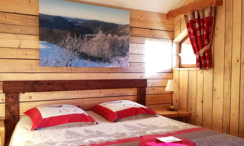 Ambiance chalet en bois, lit avec motifs traditionnels