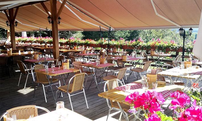 Terrasse couvert d’un grand parasol avec vue sur les montagnes