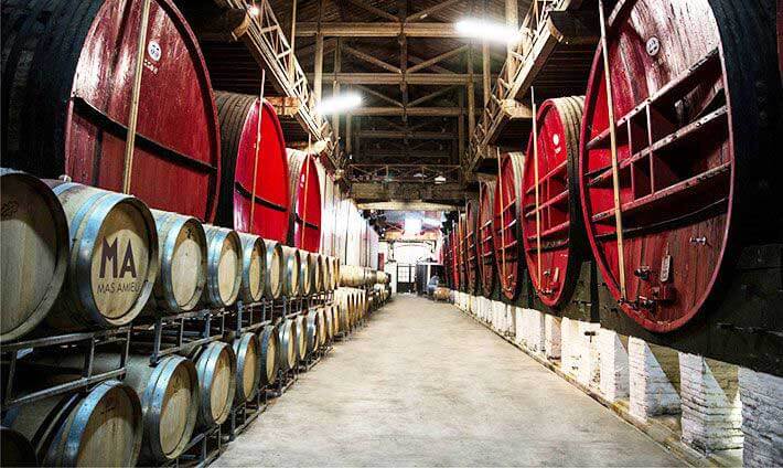 Grande allée avec des rangées de gros tonneaux rouges