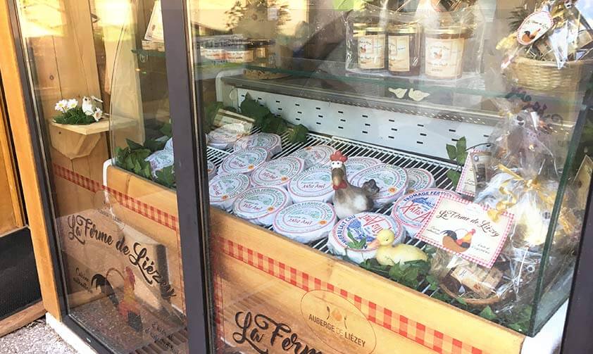 Grande vitrine avec les produits maison : fromages, confitures, ...