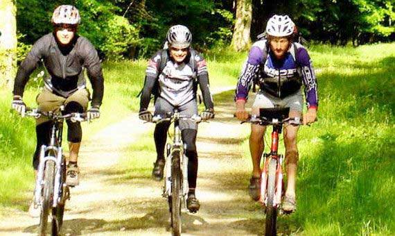 Trois cyclistes en vtt sur un chemin de forêt