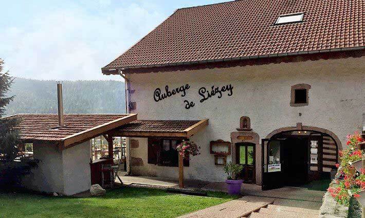 Auberge de Liézey, restaurant et hôtel Ferme typique vosgienne avec montagnes en fond